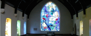 Witraże wielkich malarzy w skromnym kościele.